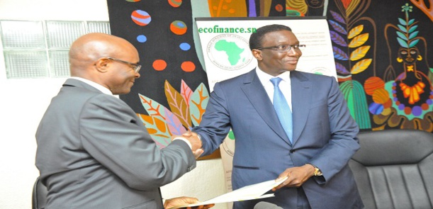 Amadou Bâ, à droite, serrant la main du représentant résident de la bad au Sénégal, après la signature de la convention de prêt pour l'hydraulique et l'assainissement.