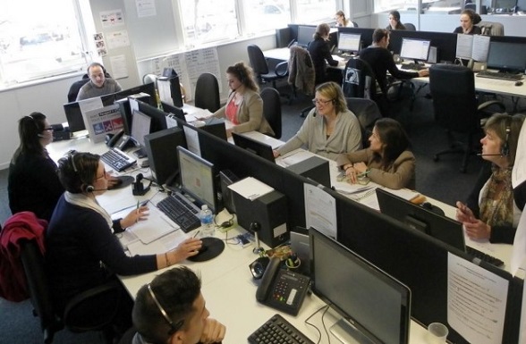 Des travailleurs en casque de standardiste avec kit mains libres et ordinateur connecté à Internet.