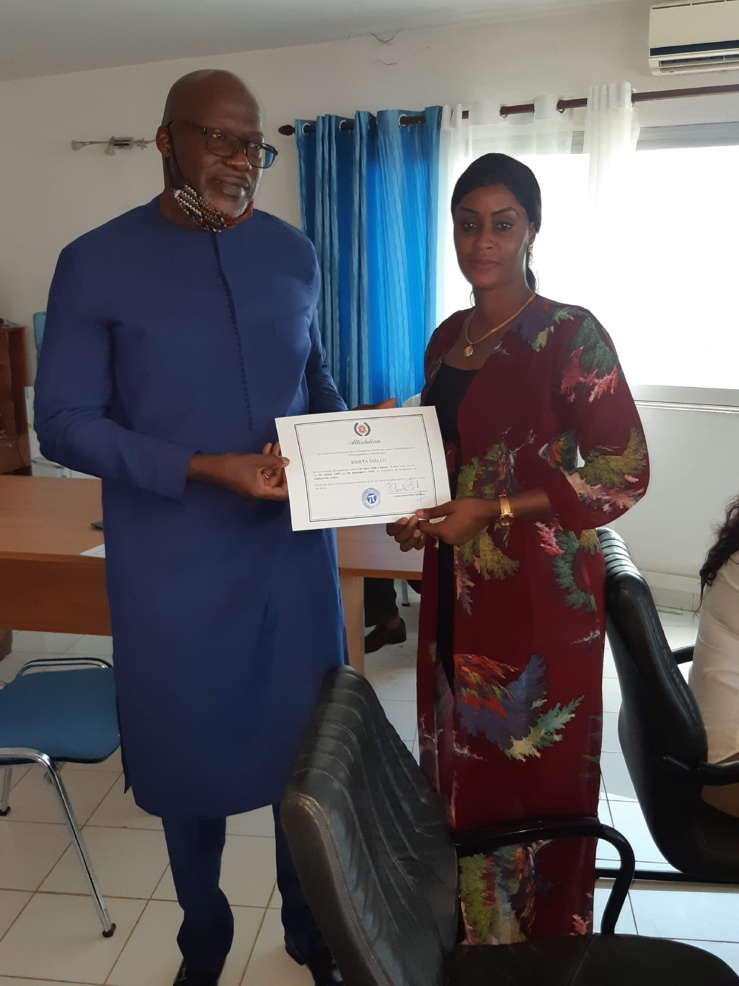 Une jeune stagiaire recevant son certificat de fin formation sur la gestion de caisse et l'environnement bancaire. Une jeune stagiaire recevant son certificat de fin formation sur la gestion de caisse et l'environnement bancaire.