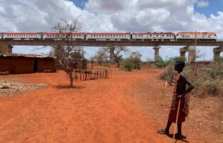 Un jeune homme regarde un train de passagers du chemin de fer à écartement standard survoler sa maison dans le comté de Taita Taveta, dans le sud-est du Kenya. Auteur fourni Un jeune homme regarde un train de passagers du chemin de fer à écartement standard survoler sa maison dans le comté de Taita Taveta, dans le sud-est du Kenya. Auteur fourni