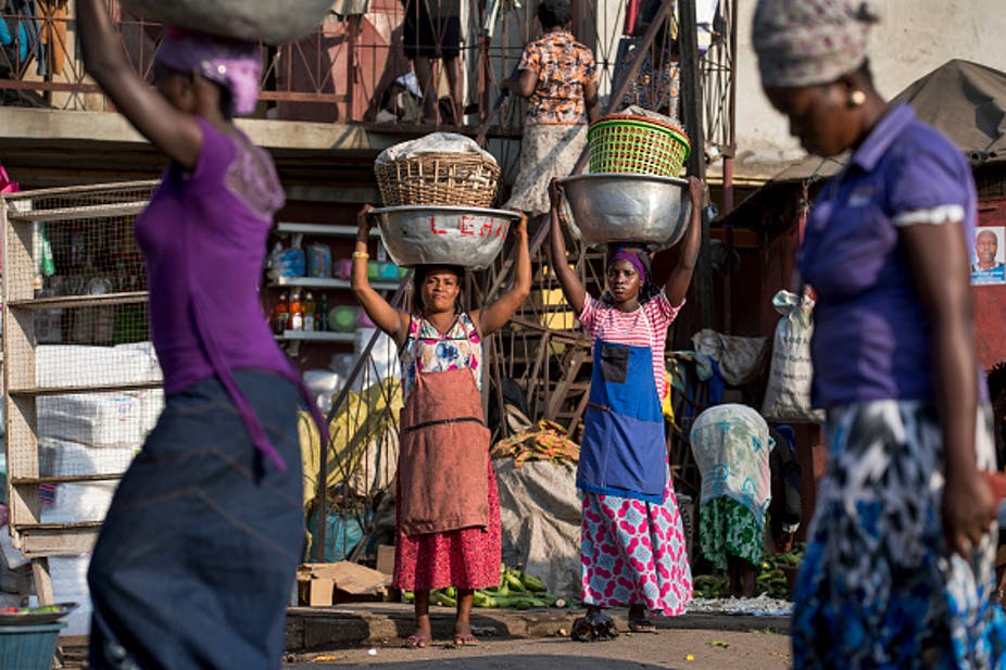 Les travailleurs informels en chef des porteurs Percent Boatemaq (à gauche) et Lusaka Fuseina (à droite) transportant des marchandises sur la tête au marché d'Agbogbloshie à Accra, au Ghana. Photo de Jonathan Torgovnik/Getty Images