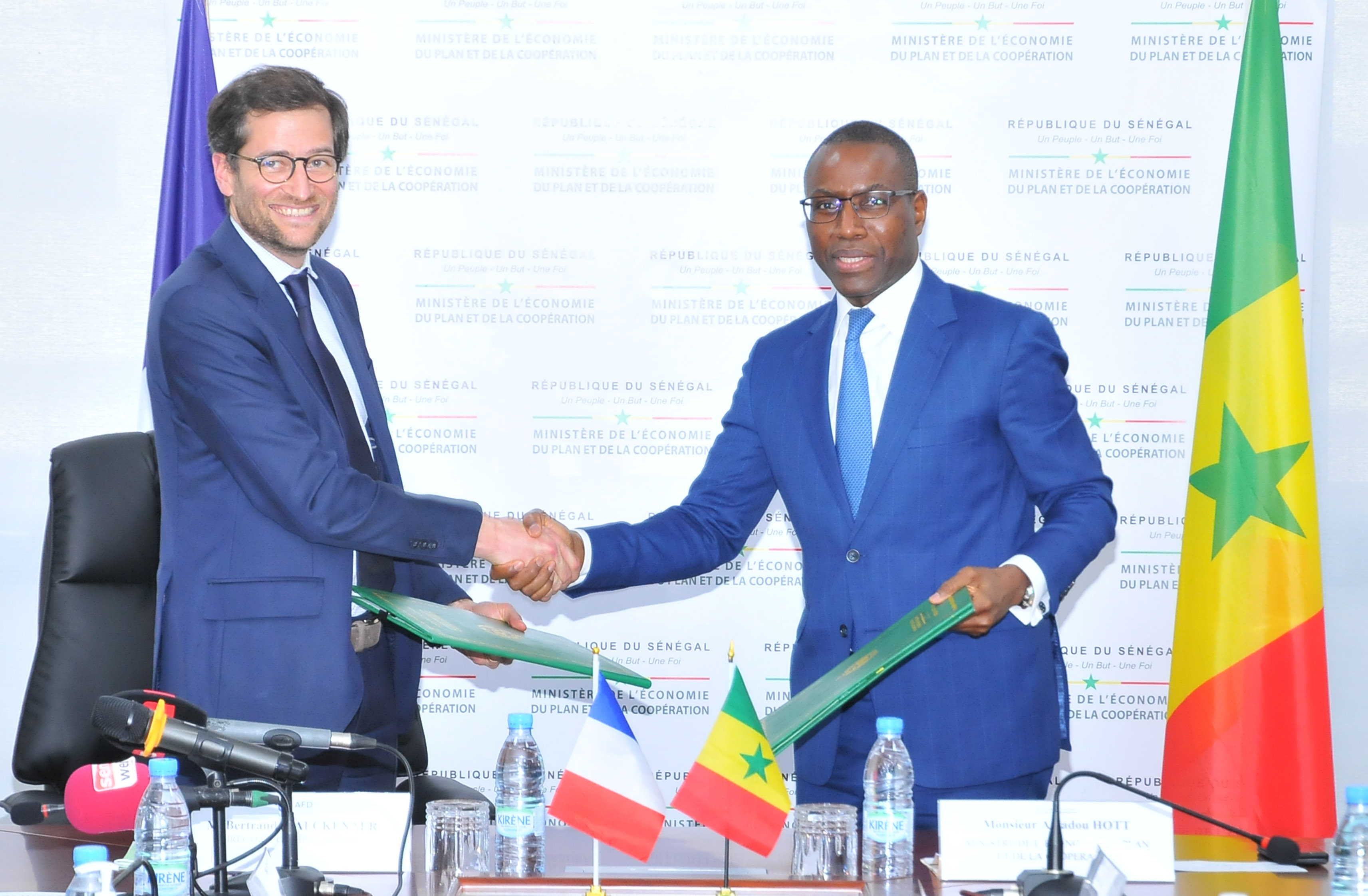 Echange de document entre Amadou Hott, Ministre de l’Economie, du Plan et de la Coopération, et Bertrand Walcknaer, Directeur général adjoint de l’AFD, après la signature d’un protocole d’accord visant à renforcer la dynamique entrepreneuriale du Sénégal. Echange de document entre Amadou Hott, Ministre de l’Economie, du Plan et de la Coopération, et Bertrand Walcknaer, Directeur général adjoint de l’AFD, après la signature d’un protocole d’accord visant à renforcer la dynamique entrepreneuriale du Sénégal.