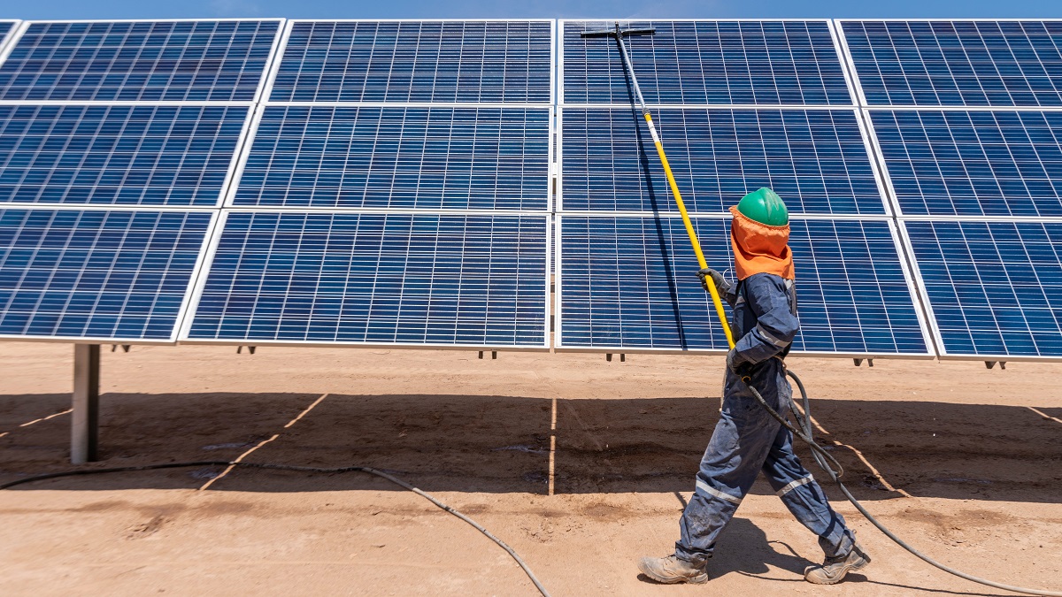 © Shutterstock/abriendomundo | Un ouvrier nettoie des panneaux solaires dans le désert d'Atacama, au Chili.